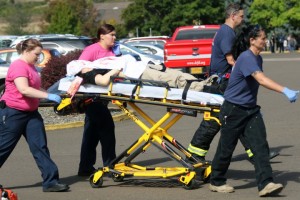 Authorities carry a shooting victim away from the scene after a gunman opened fire at Umpqua Community College in Roseburg, Ore., Thursday, Oct. 1, 2015. (Mike Sullivan/Roseburg News-Review via AP)